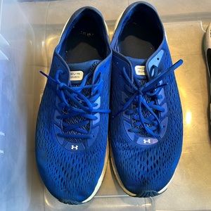 Royal blue and white HOVR under armour tennis shoes